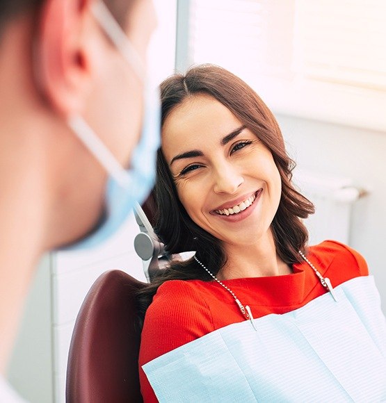 Woman in dental chair smiling at dentist