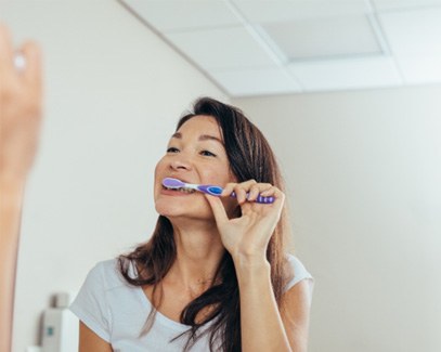 Woman brushing her teeth in bathroom