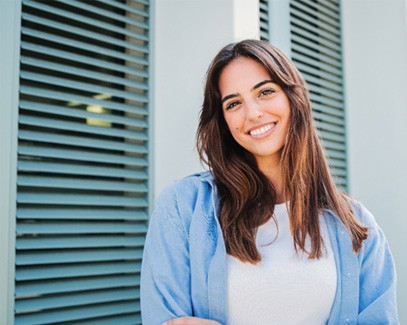 Woman with white teeth smiling while standing outside