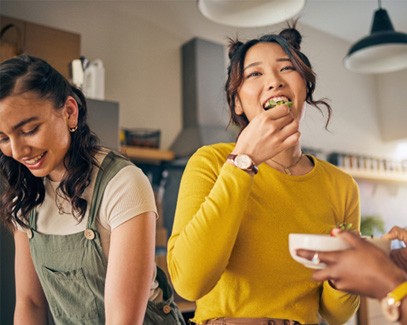 Group of friends smiling while eating together