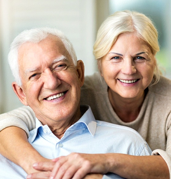 Older couple smiling with arms around each other