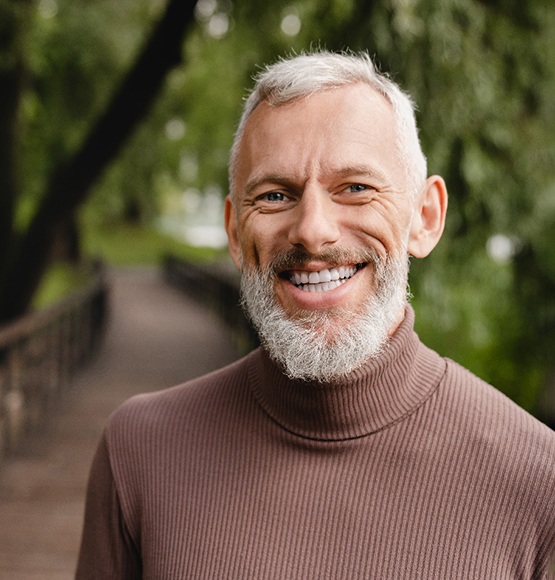 Bearded man walking on a wooden bridge