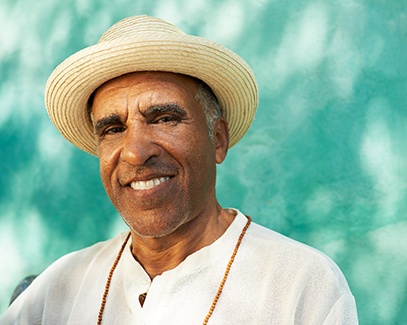 Senior man in a hat standing and smiling