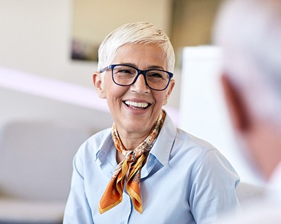 Senior woman sitting down and speaking to someone