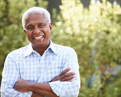 Senior man standing with his arms folded