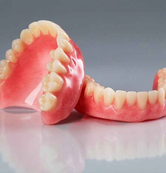 Upper and lower dentures in Tucson on reflective table