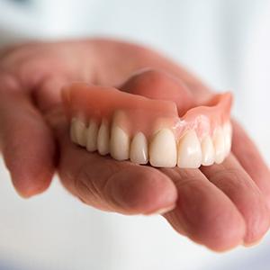 a person holding a set of dentures