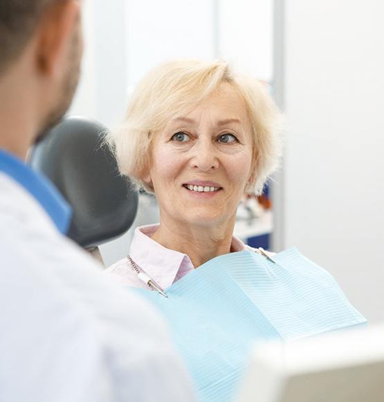 woman smiling after getting dentures