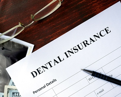 Dental insurance form and X-ray on a desk