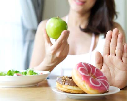 person choosing to eat an apple instead of a donut