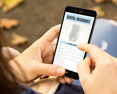 Woman looking at dental insurance form on phone