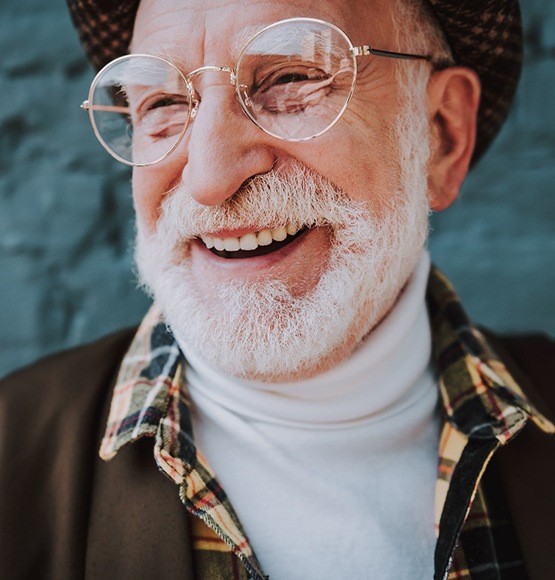 man smiling after getting dental implants in Tucson