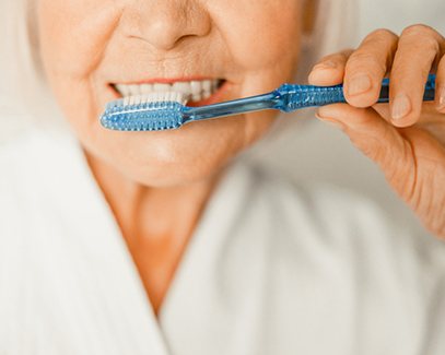 older woman brushing her teeth