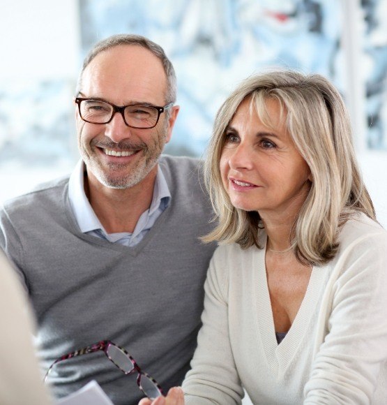 Man and woman discussing dental implant tooth replacement with dentist