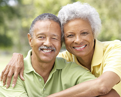 Smiling couple with dental implants in Tucson outside 