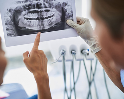 Tucson implant dentist and patient looking at an X-ray