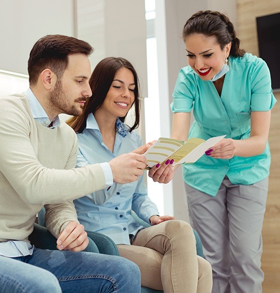 Dental team member giving patients dental insurance information