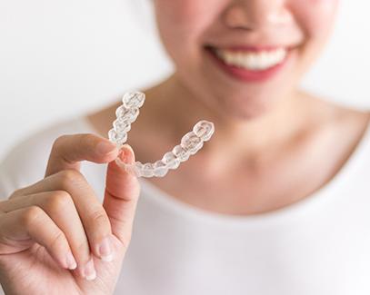 Closeup of woman holding Invisalign in Tucson