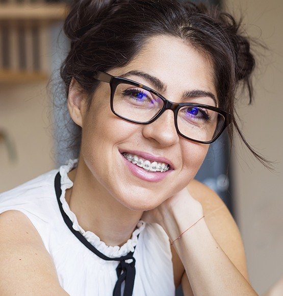 Smiling woman with traditional braces orthodontics