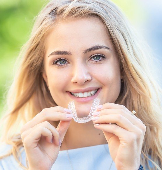Woman placing Invisalign clear aligner tray