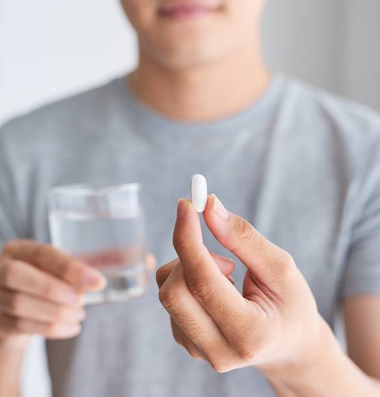 Patient holding oral conscious dental sedation pill