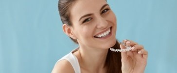 Woman placing her Invislaign clear aligner during orthodontic treatment