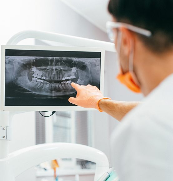 Dentist pointing to all digital dental x-rays