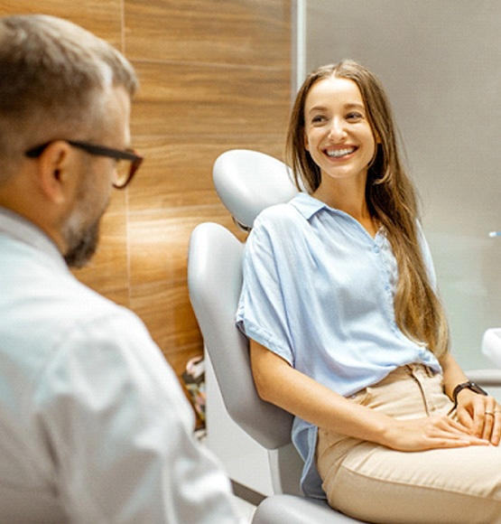 Smiling patient talking to cosmetic dentist about teeth whitening in Tucson