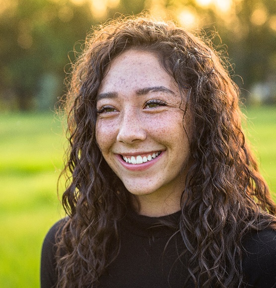 a smiling teenager walking in the park