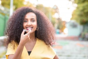 a woman putting her Invisalign aligners in her mouth