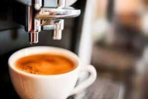 An espresso machine pouring out a shot of espresso