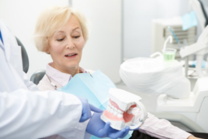 Dentist pointing to a dental model while talking to patient
